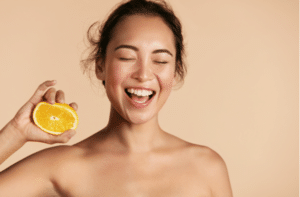 Smiling woman with radiant face skin and orange portrait.